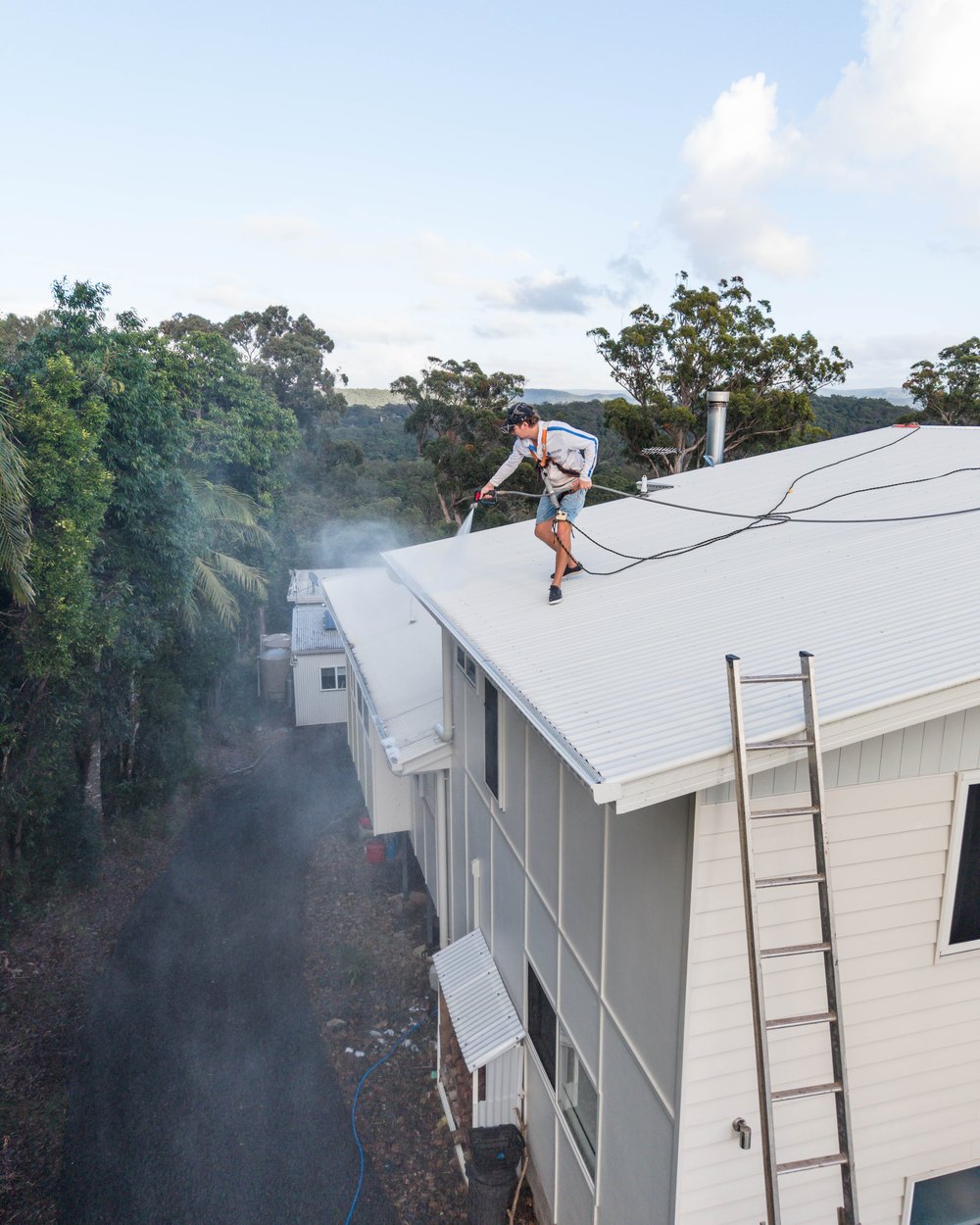 Max Thomson, owner of Ultimate Pressure Washing, cleaning a roof